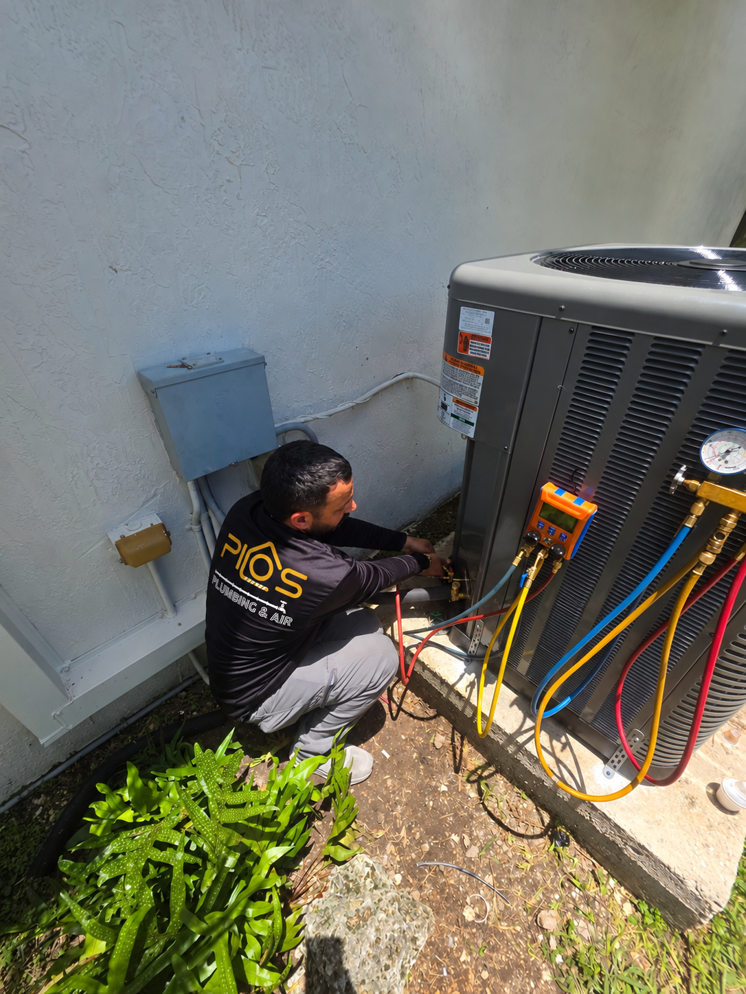 Technician servicing an outdoor air conditioning unit